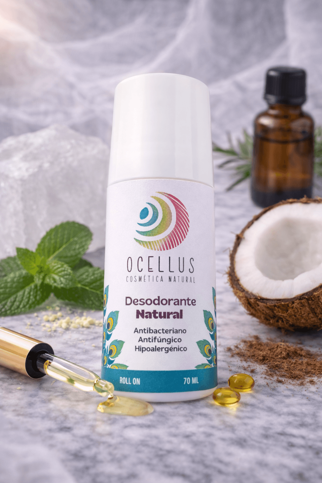 Desodorante natural Ocellus rodeado de coco, menta y aceites esenciales sobre una superficie marmoleada.